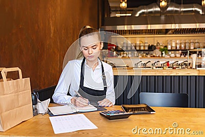 Small family restaurant owner doing finance calculating bills and expenses of small business Stock Photo