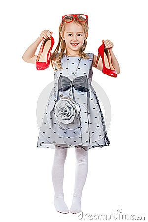A small fashionista holds red shoes in her hands Stock Photo