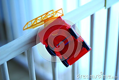 Small fire truck kids toy on a wooden baby cot Stock Photo