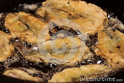 Small fish fry in a pan. Fried fish in a frying pan. Small crispy fish are fried in oil. Stock Photo