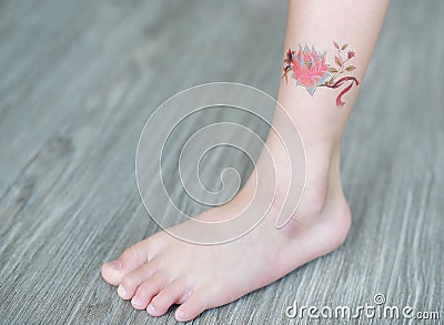 Small flower tattoo sticker on child ankle, Dress up tattoo Stock Photo