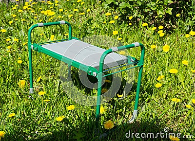 small folding garden bench for weeding. green water. Stock Photo