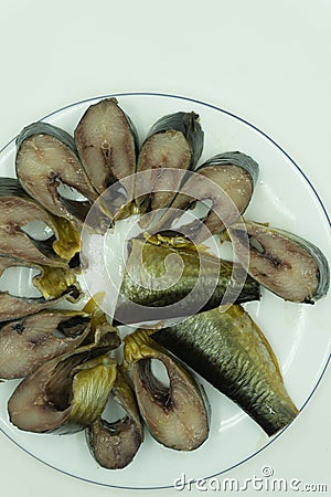 Small fried fish and cut into rings of tomatoes on a slice of bread. Stock Photo