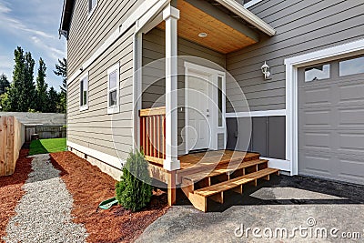 Small front porch with stairs and white entrance door. Stock Photo