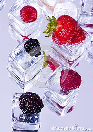 Small fruits among ice cubes Stock Photo