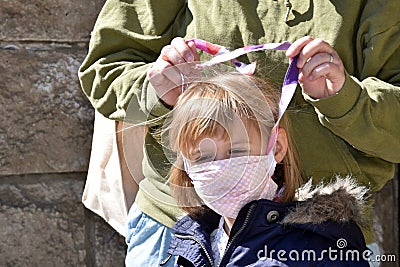 Small girl with facemasks against coronavirus. Stock Photo
