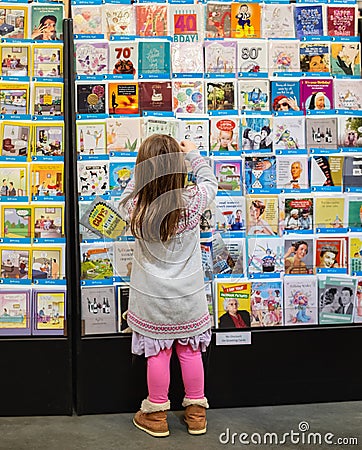 Small girl happy shopping. A girl in a gift cards sections in the shop. Present and gifts buy Editorial Stock Photo