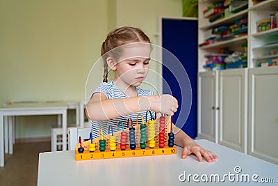 Small girl learning to add and subtract accounts. Stock Photo