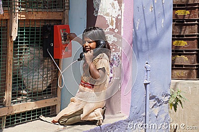 Small girl making a phone call in rural India Editorial Stock Photo