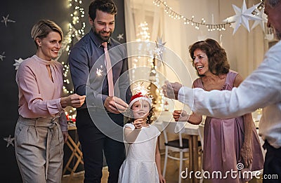 Small girl with parents and grandparents indoors celebrating Christmas. Stock Photo