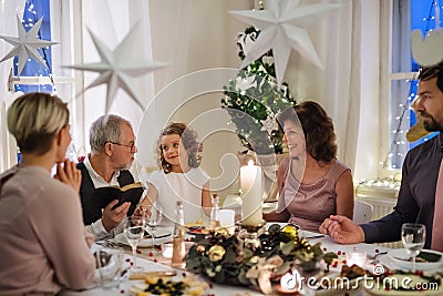 Small girl with parents and grandparents indoors celebrating Christmas. Stock Photo