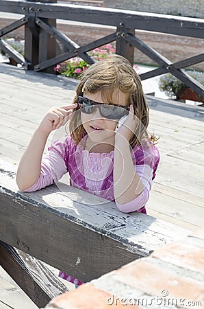 Small girl talking to a mobile phone Stock Photo