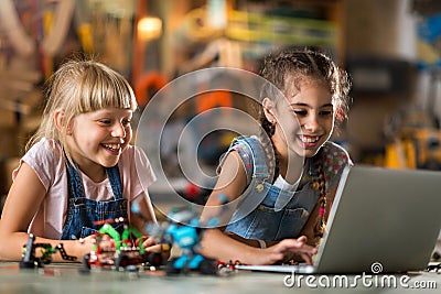 Girls cooperating while making a robot Stock Photo