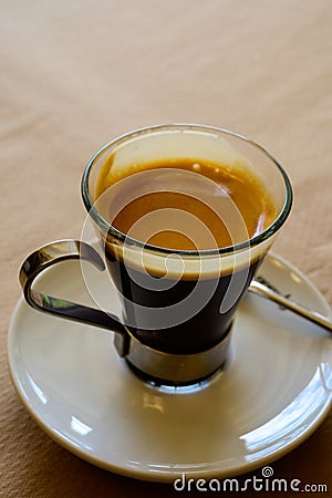 Small glass cup of black arabica coffee served in cafe, close up Stock Photo