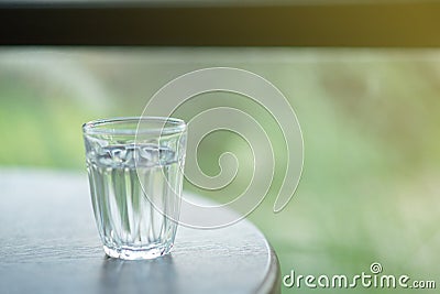 A small glass of water filled with water placed on the table Stock Photo