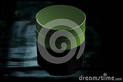 Small green jar in water with reflection on a dark background. Mockup for advertising cream, lation, moisturizing milk Stock Photo