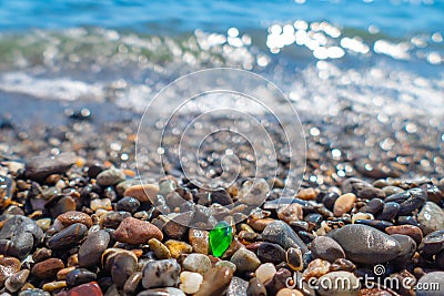 Green polished glass pebble on seashore Stock Photo