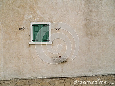 Small green window on plain stone wall Stock Photo