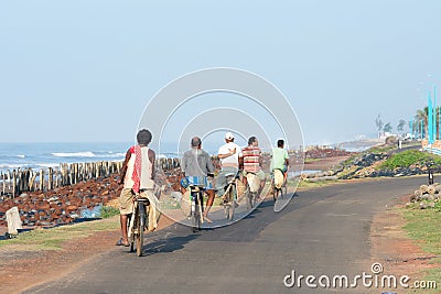 Small group of young and middle aged village people in remote coastal area returning home from work in bicycles. Cycle is the Editorial Stock Photo
