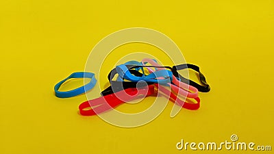 Small hair tie bands are colorful and unique on yellow background. Stock Photo