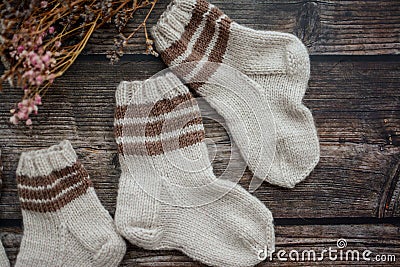 Small handmade baby socks on dark wooden background Stock Photo