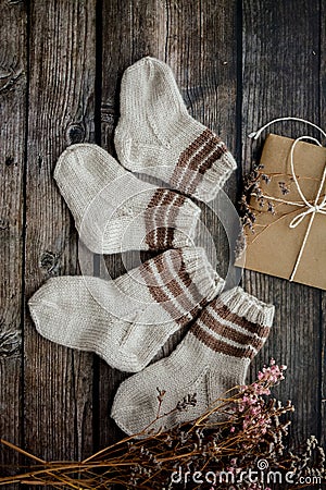 Small handmade baby socks on dark wooden background Stock Photo