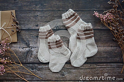 Small handmade baby socks on dark wooden background Stock Photo