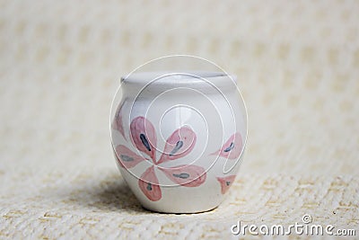 Small handmade white clay pot for making wishes or flowers from boutonnieres. Decor engobe, covered with transparent glaze, two Stock Photo