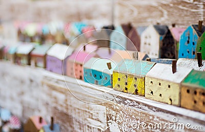 Small handmade wooden houses in a row on store shelf. Craft, home decor concept. Scandinavian, country style Stock Photo