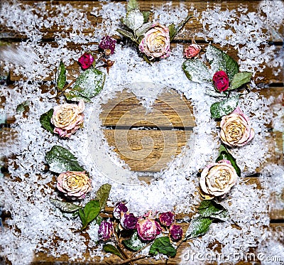 A small heart laid out of snow on a wooden table Stock Photo