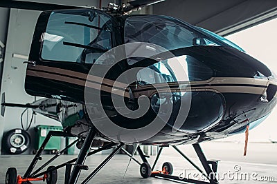 Small helicopter in hangar, private airline copter Stock Photo
