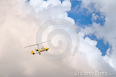 Small helicopter for two person flying on the cloudy sky Stock Photo