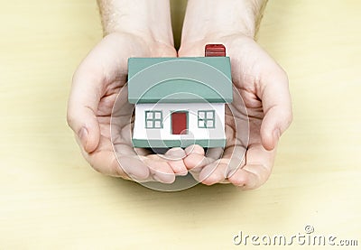 A small house with a red pipe in the hands of a man. Concept mortgage, purchase, sale, rental property. Happiness in his house, Stock Photo
