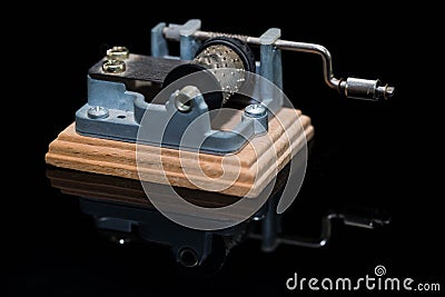 Small hurdy gurdy music box on black shiny reflecting surface Stock Photo