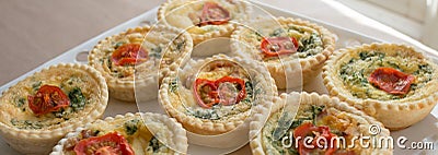 Small Individual Quiche Topped with Tomato and Parsley. Stock Photo