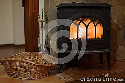 Small iron stove with straw basket Stock Photo