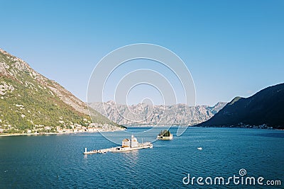 Small islands in the Bay of Kotor surrounded by a mountain range. Montenegro. Drone Stock Photo