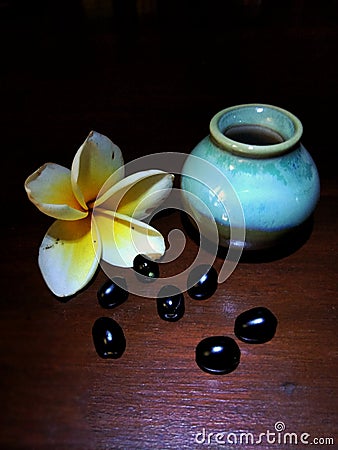 Small jar with frangipani flowers and grains Stock Photo