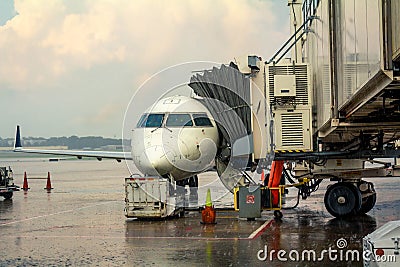 Small jet airplane with attached jetway at airport gate terminal Stock Photo