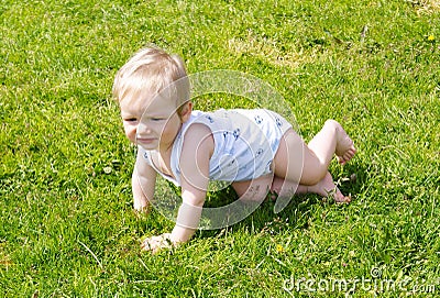 The small kid creeps on a grass Stock Photo