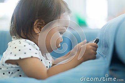 Small kid that spends too much time watching tv on a mobile phone Stock Photo
