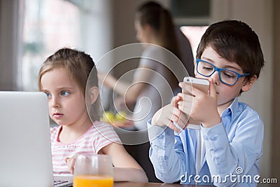 Small kids using gadgets playing games or watching video Stock Photo