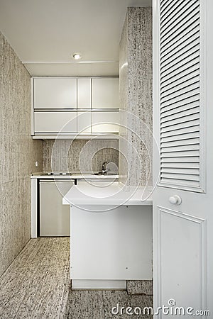 Small kitchen with white wooden furniture in a cubicle Stock Photo