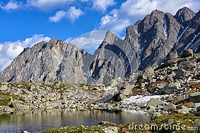 Small lake in hanging valley and mountain peaks Stock Photo