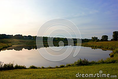 Small Lake reflection with grass shore area Stock Photo