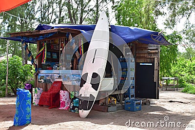 Small local open shop on the beach with large choice of items from Surfboard to rent to clothes and drinks. Small business backgro Editorial Stock Photo