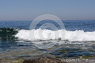 Small lonely wave breaks in the calm sea Stock Photo
