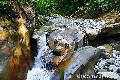 Small lovely waterfall in mountain forest Stock Photo