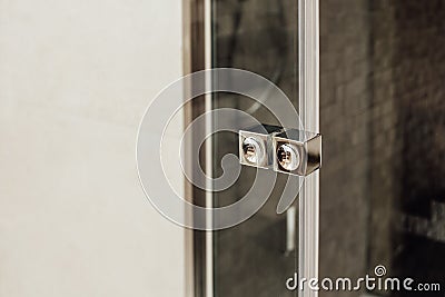 Small metal handle for a glass door in a shower cabin view in the interior Stock Photo
