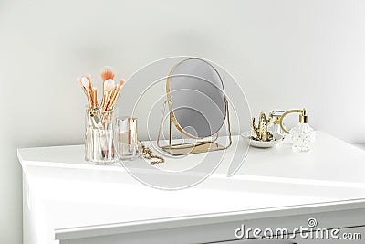 Small mirror and makeup products on dressing table indoors Stock Photo